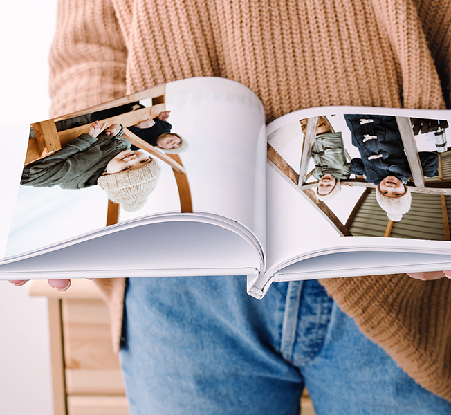 Open photobook featuring photos of parents playing with their children